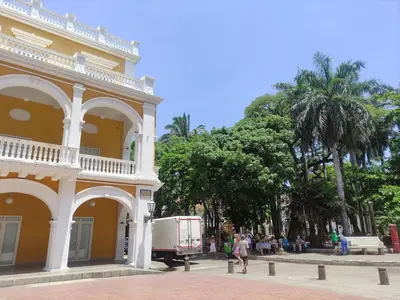 a yellow building with a food truck parked next to it at Apartamento Cartagena 180, vista espectacular in Cartagena de Indias