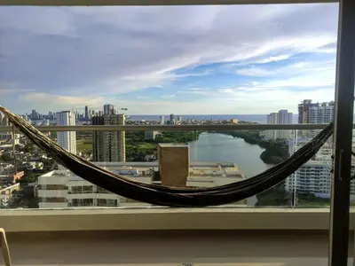 a hammock in a window with a view of a city at Apartamento Cartagena 180, vista espectacular in Cartagena de Indias