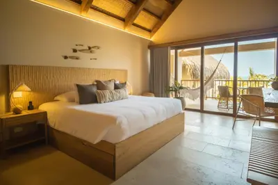 a bedroom with a large bed and a balcony at Hotel Aimarawa in Coveñas