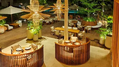 a restaurant with tables and chairs and umbrellas at Hotel Aimarawa in Coveñas