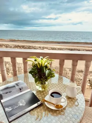 a table with a laptop and a cup of coffee on the beach at Moet Cartagena Hotel Boutique Adutls Only in Cartagena de Indias