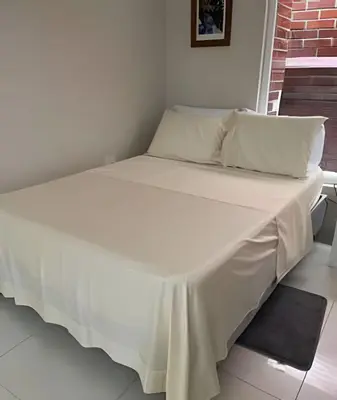 a bed with a white sheet on top of it at 306Hermoso, céntrico y acogedor loft en Cartagena in Cartagena de Indias
