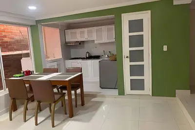 a kitchen with green walls and a table and chairs at 306Hermoso, céntrico y acogedor loft en Cartagena in Cartagena de Indias