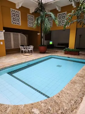 a large pool with a table and chairs in a courtyard at Hermoso Apto en el corazón de la ciudad amurallada in Cartagena de Indias