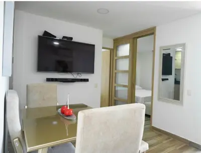 a dining room with a table and a television on a wall at Exclusive House Cartagena in Cartagena de Indias