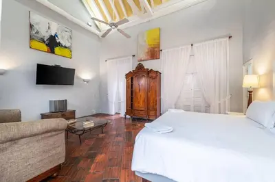 a bedroom with a white bed and a couch at Amazing Colonial Mansion Old City Cartagena in Cartagena de Indias