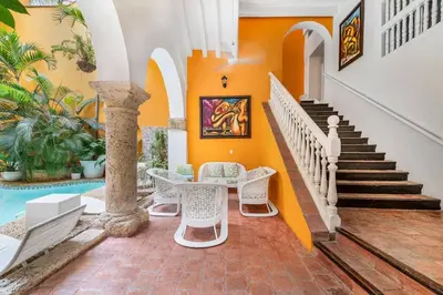 a staircase in a house with chairs and a table at Amazing Colonial Mansion Old City Cartagena in Cartagena de Indias