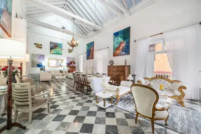 a living room with chairs and a table in a room at Amazing Colonial Mansion Old City Cartagena in Cartagena de Indias