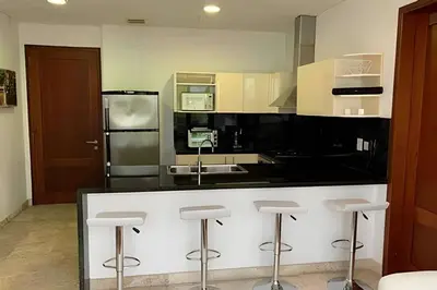 a kitchen with a black counter and stools at 212 Cartagena Walled City Magical Apt in Cartagena de Indias