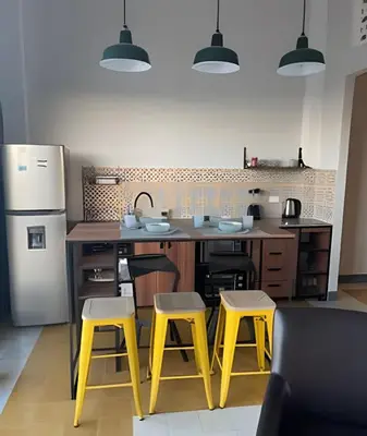 a kitchen with yellow stools and a kitchen with a refrigerator at 417 Apto con vista panorámica de cgna in Cartagena de Indias