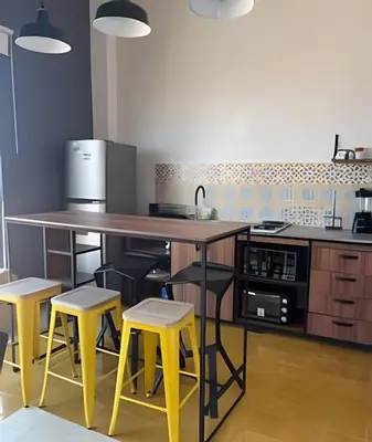 a kitchen with a large island with yellow stools at 417 Apto con vista panorámica de cgna in Cartagena de Indias