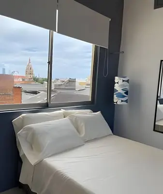 a bed with white pillows and a window with a view at 417 Apto con vista panorámica de cgna in Cartagena de Indias