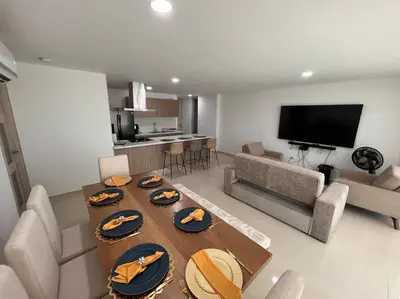 a living room with a table with plates of food on it at Excelente Apartamento en Villa Campestre, Barranquilla in Puerto Colombia
