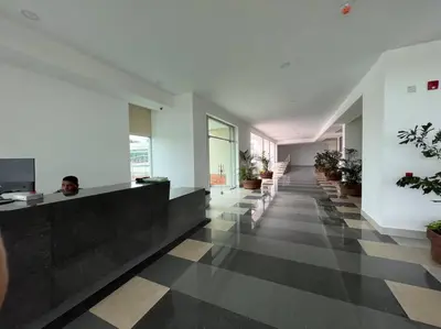 a man sitting at a reception desk in a lobby at Excelente Apartamento en Villa Campestre, Barranquilla in Puerto Colombia
