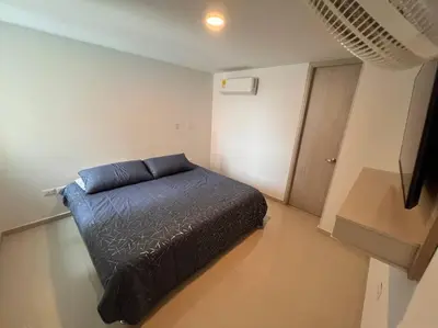 a bedroom with a bed with a blue blanket at Excelente Apartamento en Villa Campestre, Barranquilla in Puerto Colombia