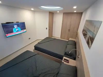 a room with two beds and a flat screen tv at APARTAMENTO MODERNO EL LAGUITO JUNTO AL MAR 705 in Cartagena de Indias