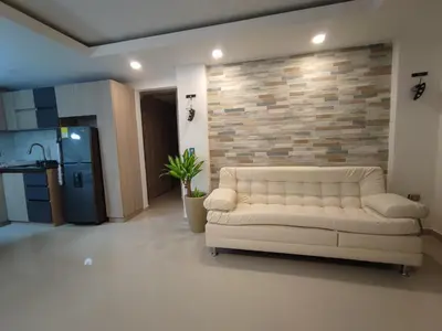 a white couch in a living room with a brick wall at APARTAMENTO MODERNO EL LAGUITO JUNTO AL MAR 705 in Cartagena de Indias