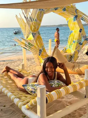 a woman laying on a beach chair on the beach at Mio Mio Beach in Baru