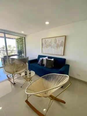 a living room with a blue couch and two chairs at Ocean Drive Beach House - Cartagena in Cartagena de Indias
