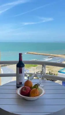 a plate of fruit on a table with a bottle and glasses at Cabrero Beach 1212 in Cartagena de Indias