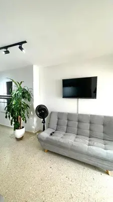 a living room with a couch and a flat screen tv at Cabrero Beach 1212 in Cartagena de Indias