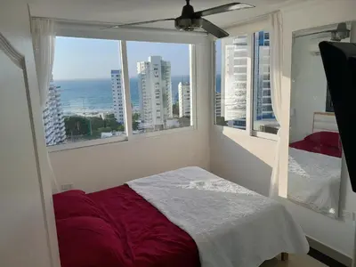 a bedroom with a bed and a view of the ocean at Oceanside 3-bedroom apartment in fun tourist area in Cartagena de Indias