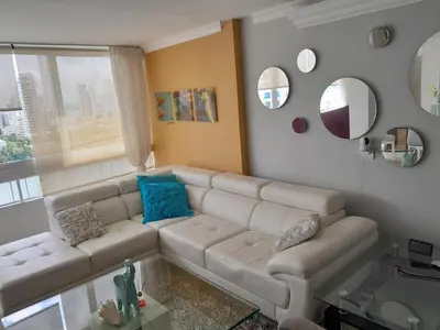 a living room with a white couch and mirrors at Oceanside 3-bedroom apartment in fun tourist area in Cartagena de Indias