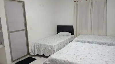 a bedroom with two beds and a mirror at Cabaña Rochy in Coveñas