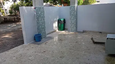 a white fence with a green trash can next to it at Cabaña Rochy in Coveñas