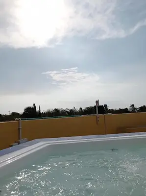 a swimming pool with water in front of a fence at Casa Amarilla in Santa Veronica
