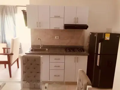 a kitchen with white cabinets and a black refrigerator at Cabañas Paulamar - Apto 2 - Tolu in La Gloria