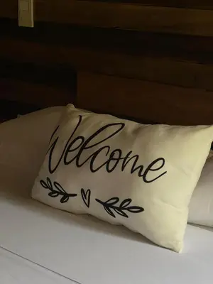 a pillow with the word welcome written on it on a bed at Cristal Blue Barú in Baru
