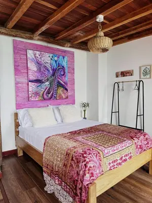 a bedroom with a bed with a painting on the wall at Cristal Blue Barú in Baru