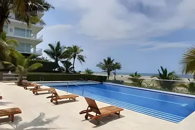 a swimming pool with benches and a building at Apartamento 1 Dormitorio Morros. Vista Mar Piscina in Cartagena de Indias