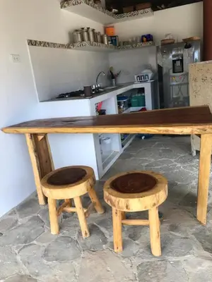 a wooden table and stool in a kitchen at Kamajorú Ecohabitat in Tubará