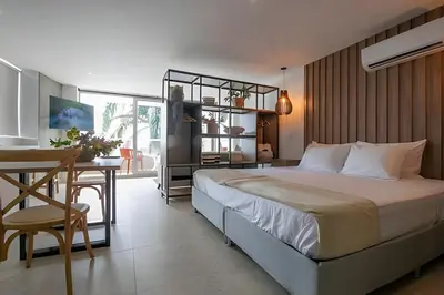 a bedroom with a bed and a table and a desk at Laurdhomes Laguito Loft Hot Ware 1Bath, lake view in Cartagena de Indias