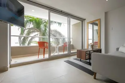 a living room with a couch and a large window at Laurdhomes Laguito Loft Hot Ware 1Bath, lake view in Cartagena de Indias