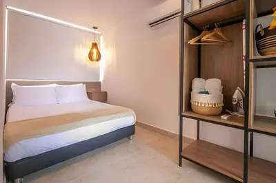 a bedroom with a bed and a shelf with towels at Laurdhomes Laguito Loft , Hot Ware, 1Bath in Cartagena de Indias