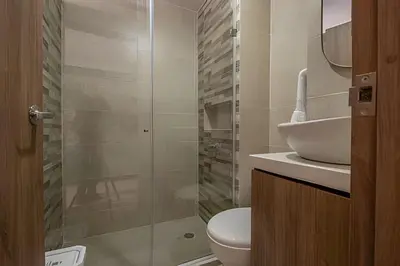 a bathroom with a toilet and a glass shower at Laurdhomes Laguito Loft , Hot Ware, 1Bath in Cartagena de Indias