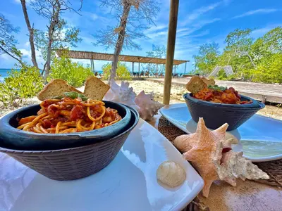a table with two bowls of pasta and a starfish at Medusa Hostel Isla Tintipan in Tintipan Island
