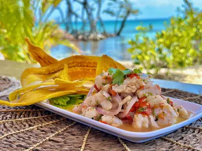 a plate of food with shrimp and chips on a table at Medusa Hostel Isla Tintipan in Tintipan Island