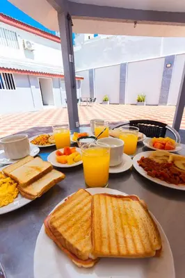 a table topped with plates of breakfast foods and orange juice at Hotel Med Suites 94 in Barranquilla