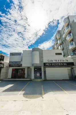 a building with a parking lot in front of it at Hotel Med Suites 94 in Barranquilla