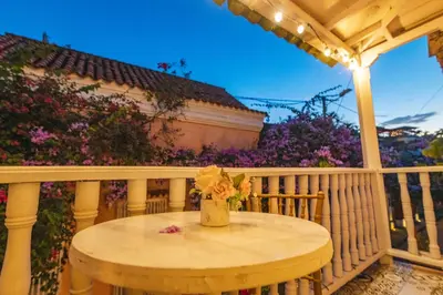 a vase of flowers sitting on a table on a porch at CASA HADASA in Cartagena de Indias