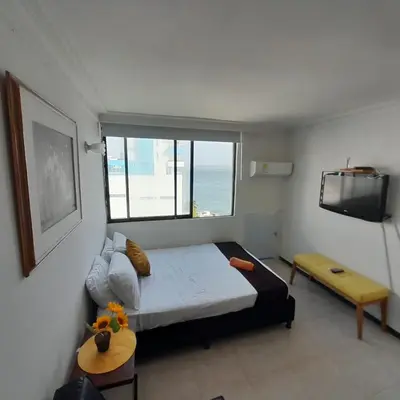 a bedroom with a bed and a television in it at Acogedor Apartamento Cartagena in Cartagena de Indias