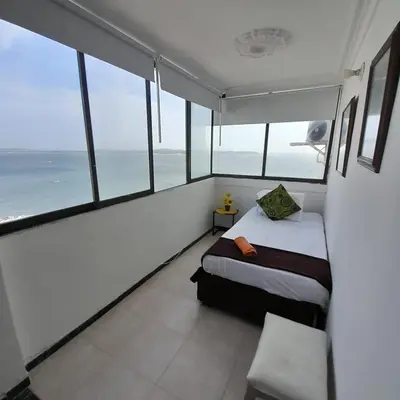 a bedroom with a bed and a view of the ocean at Acogedor Apartamento Cartagena in Cartagena de Indias