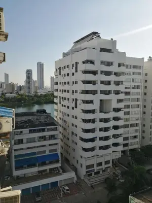 a tall white building with a river in the background at Acogedor Apartamento Cartagena in Cartagena de Indias