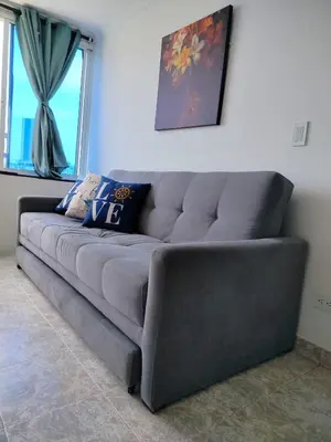 a gray couch in a living room with windows at Cartagena ApartaSuite El Laguito in Cartagena de Indias