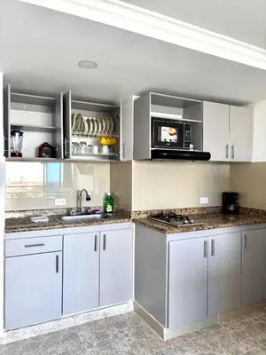 a kitchen with white cabinets and a microwave at Cartagena ApartaSuite El Laguito in Cartagena de Indias