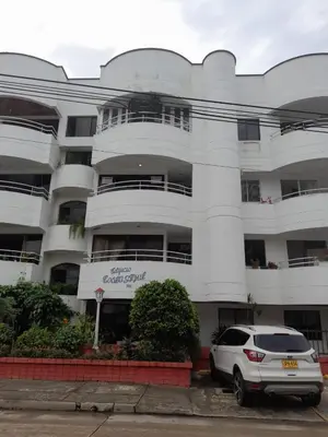 a white building with a car parked in front of it at Condominio en la Playa de Crespo in Cartagena de Indias